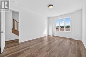 Oakville (Jm Joshua Meadows) townhouse for rent - A room with a wooden floor and a window overlooking a landscape.