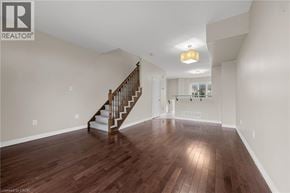 Grimsby townhouse for rent - A spacious room with a wooden floor and a staircase.