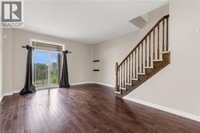 Grimsby townhouse for rent - A spacious room with a staircase and a sliding glass door.