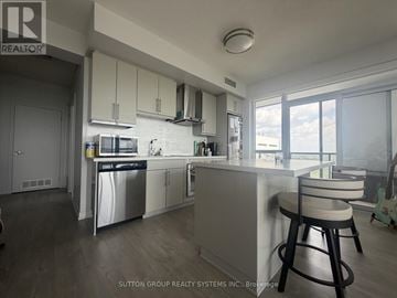 Burlington (Freeman) condo for rent - A modern kitchen with white cabinets and a large island.