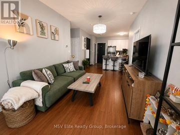 Mississauga (Fairview) condo for rent - A living room with a green couch and a wooden floor.