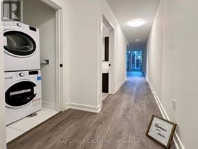 Toronto (Mount Pleasant West) condo for rent - A hallway with a washing machine in the corner and a picture frame on the floor.