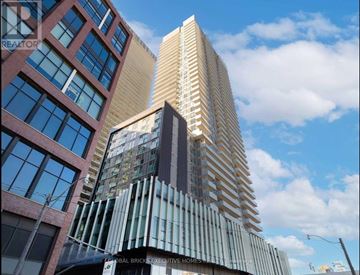 Toronto (Waterfront Communities) condo for rent - A tall building with a sign that reads "Global Bricks Executive Homes".