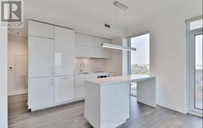 Toronto (Waterfront Communities) condo for rent - A white kitchen with a large island and a window.