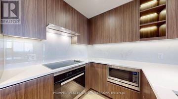 Toronto (Bayview Village) condo for rent - A modern kitchen with wooden cabinets and stainless steel appliances.