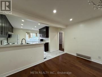 Toronto (Bendale) apartment for rent - A well-lit kitchen with dark wood cabinets and a white countertop.