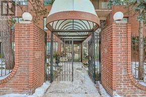 Toronto (The Beaches) multi-family for rent - The entrance to a building with a red brick wall and a white dome above the gate.
