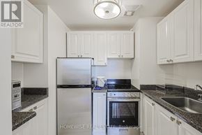 Toronto (The Beaches) multi-family for rent - A kitchen with white cabinets and a black stove top.