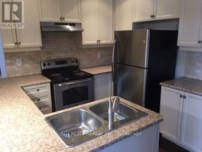 Vaughan (Patterson) townhouse for rent - A kitchen with a black refrigerator and stove.