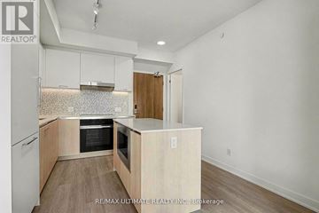 Vaughan (Uplands) condo for rent - A kitchen with white cabinets and a wood floor.