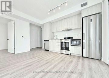 Vaughan (Vaughan Corporate Centre) condo for rent - A modern kitchen with white cabinets and stainless steel appliances.