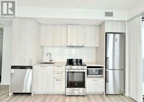 Vaughan (Vaughan Corporate Centre) condo for rent - A modern kitchen with white cabinets and stainless steel appliances.