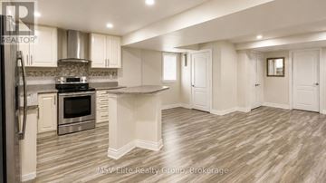 Brampton (Sandringham-Wellington) apartment for rent - A modern kitchen with a stainless steel refrigerator and a center island.