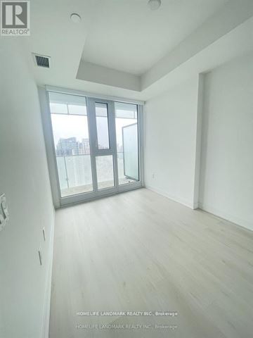 Mississauga (City Centre) condo for rent - A room with a sliding glass door and wooden flooring.