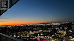 Mississauga (City Centre) condo for rent - A cityscape at dusk with a sign that reads REALTOR.