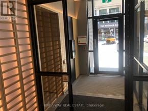 Milton (Cb Cobban) condo for rent - A view of a hallway with a glass door and a sign that says "Kingsway Real Estate Brokerage".