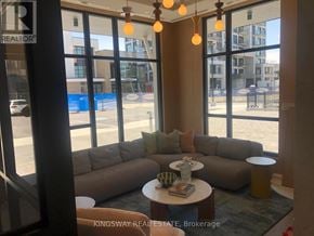 Milton (Cb Cobban) condo for rent - A living room with a couch and a table with a vase on it.