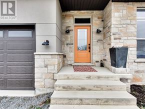 Port Colborne (Sugarloaf) apartment for rent - A house with a brown garage door and a red mat on the steps.