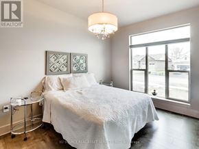 Port Colborne (Sugarloaf) apartment for rent - A bedroom with a large bed and a chandelier.