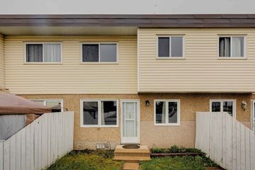 Edmonton apartment for rent - A beige house with a white door and windows.