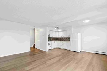 Edmonton apartment for rent - A kitchen with white cabinets and a wooden floor.