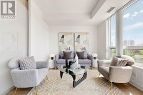 Toronto (Willowdale East) condo for rent - A living room with a grey couch, a glass coffee table, and a large window.