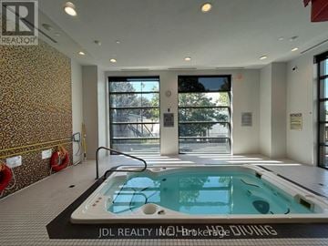 Toronto (Henry Farm) condo for rent - A hot tub in a room with a wallpapered wall and a glass door leading outside.