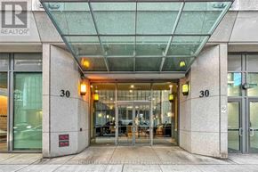 Toronto (Waterfront Communities) condo for rent - The entrance to a building with glass doors and a sign that reads "30".