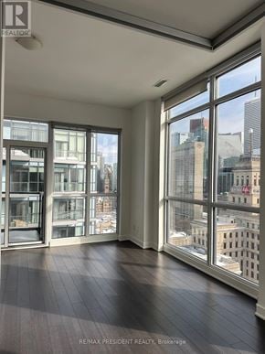 Toronto (Kensington-Chinatown) condo for rent - A room with a view of the city through large windows.