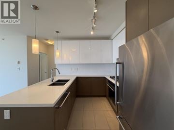 Coquitlam apartment for rent - A modern kitchen with a stainless steel refrigerator and white countertops.
