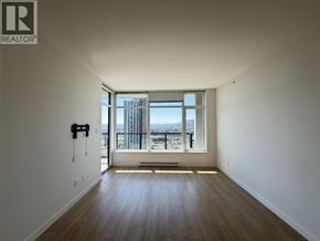Coquitlam apartment for rent - A room with a large window overlooking a cityscape.