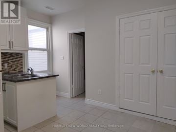Toronto (Waterfront Communities) townhouse for rent - A kitchen with white cabinets and a black countertop.