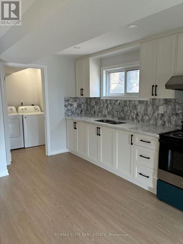 Bradford West Gwillimbury (Bradford) apartment for rent - A kitchen with white cabinets and a marble backsplash.