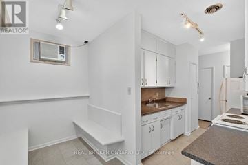 Orillia condo for rent - A kitchen with white cabinets and a bench.