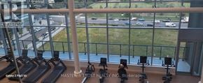 Mississauga (City Centre) condo for rent - A view from a window of a gym with treadmills and exercise bikes.