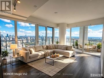 Mississauga (City Centre) condo for rent - A living room with a large sectional sofa and a view of the city.