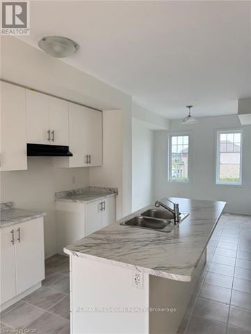 Thorold (Hurricane/Merrittville) townhouse for rent - A kitchen with white cabinets and a marble countertop.