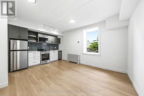 Hamilton (Corktown) multi-family for rent - A spacious kitchen with wooden flooring and white walls.