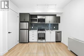 Hamilton (Corktown) multi-family for rent - A kitchen with white cabinets and stainless steel appliances.