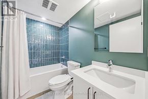 Hamilton (Corktown) multi-family for rent - A white toilet sits next to a white sink in a bathroom.
