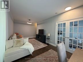 Toronto (Bayview Village) condo for rent - A living room with a couch, a chair, and a television.