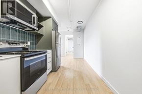 Hamilton (Corktown) multi-family for rent - A kitchen with white appliances and wood floors.