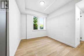Hamilton (Corktown) multi-family for rent - A white room with a window and wooden flooring.