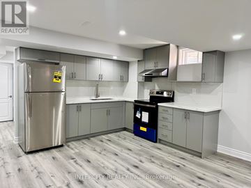 Bradford West Gwillimbury (Bradford) apartment for rent - A kitchen with a stainless steel refrigerator and wooden flooring.