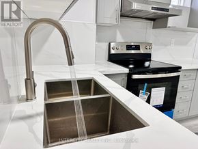 Bradford West Gwillimbury (Bradford) apartment for rent - A kitchen sink with a chrome faucet and a stainless steel dish drainer.