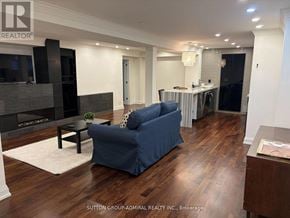 Vaughan (Maple) apartment for rent - A blue sofa in a living room with wood flooring and a fireplace.