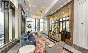 Mississauga (Fairview) condo for rent - A well-lit, modern living room with a grey sofa and a chandelier.