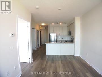 Mississauga (City Centre) condo for rent - A spacious kitchen with white cabinets and a wooden floor.