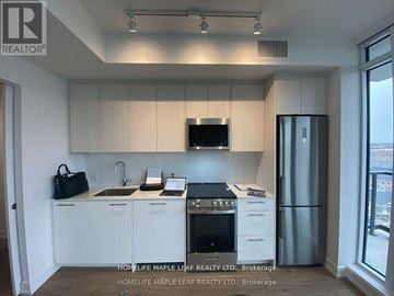 Brampton (Northwest Brampton) condo for rent - A kitchen with white cabinets and a black stove top oven.