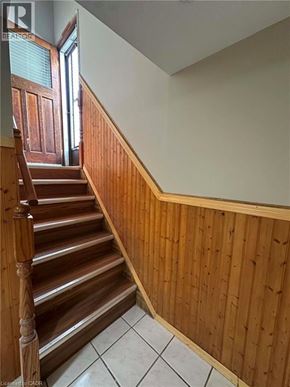 Hamilton apartment for rent - A wooden staircase with a white tiled floor.